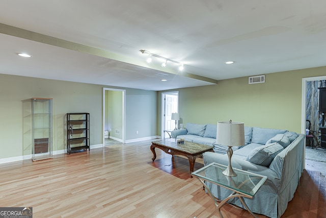 living room with light hardwood / wood-style flooring and rail lighting