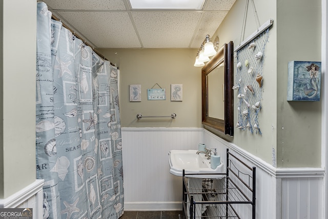 bathroom featuring tile patterned flooring, a paneled ceiling, and sink