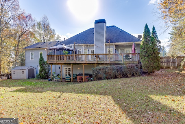 rear view of house with a yard, a storage shed, and a wooden deck