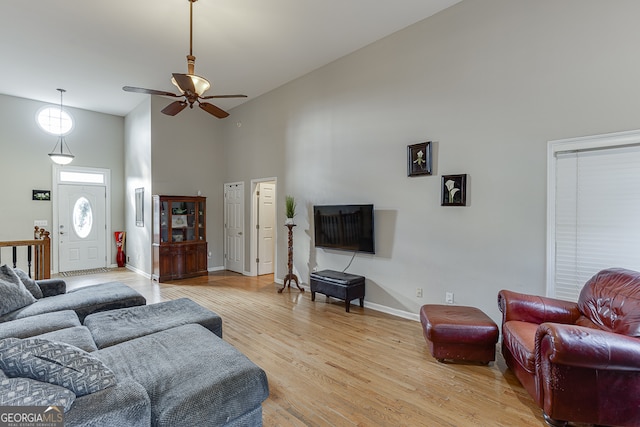 living room with ceiling fan, high vaulted ceiling, and light hardwood / wood-style floors