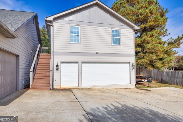 exterior space featuring stairs, board and batten siding, and fence