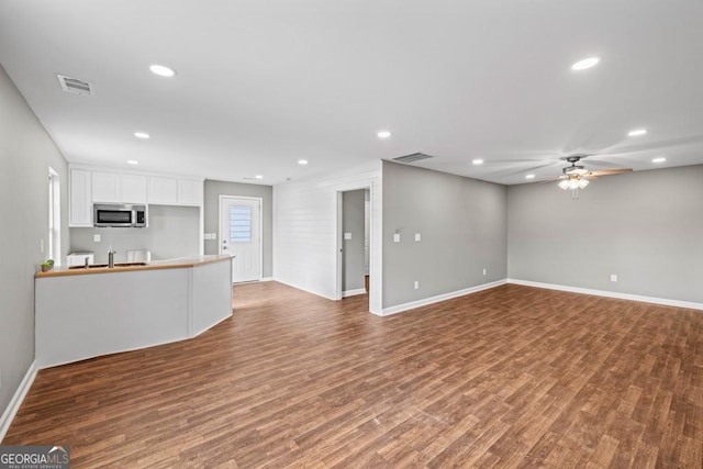 unfurnished living room featuring a ceiling fan, visible vents, wood finished floors, and recessed lighting