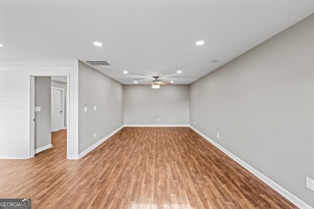 empty room with baseboards, visible vents, and wood finished floors