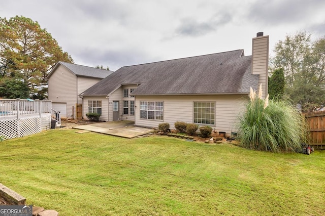 rear view of property with a chimney, fence, a lawn, and a patio