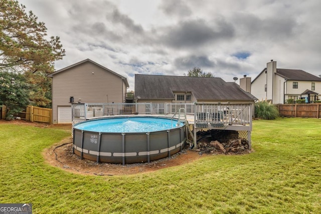 view of swimming pool featuring fence, a deck, a fenced in pool, and a yard