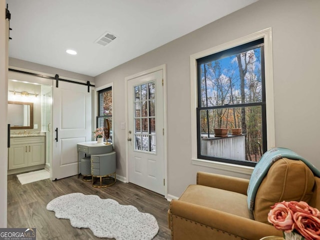 entryway with a barn door and dark wood-type flooring