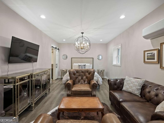 living room with a barn door, dark hardwood / wood-style flooring, an AC wall unit, and a chandelier