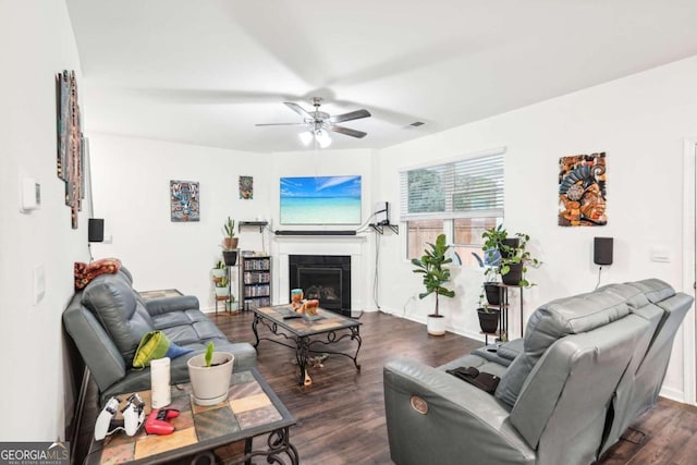 living room with ceiling fan and dark wood-type flooring