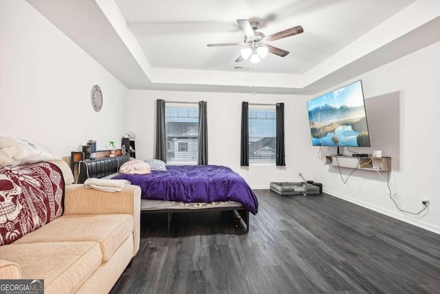 bedroom featuring a raised ceiling, ceiling fan, and hardwood / wood-style flooring