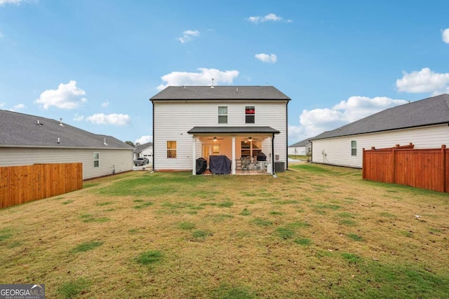 rear view of property featuring a patio area, ceiling fan, and a yard