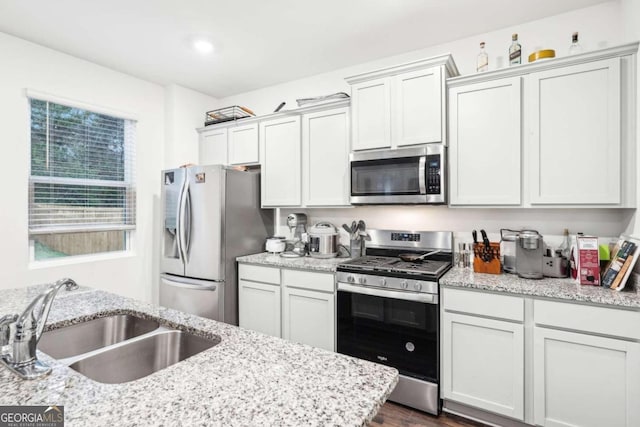 kitchen featuring dark hardwood / wood-style flooring, sink, white cabinetry, and stainless steel appliances