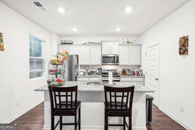 kitchen featuring a breakfast bar area, an island with sink, and stainless steel appliances