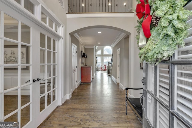 corridor with dark hardwood / wood-style flooring, ornamental molding, and french doors