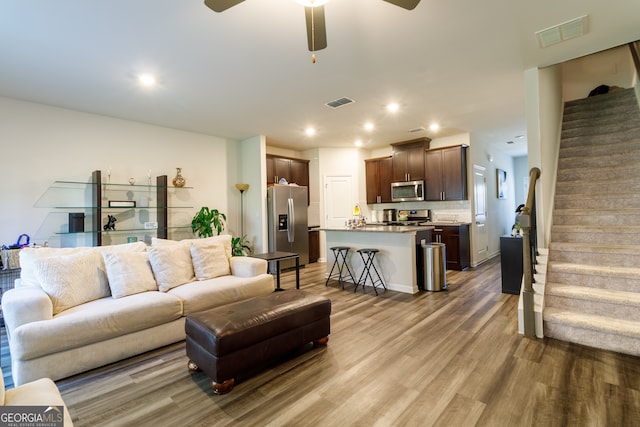 living room featuring wood-type flooring and ceiling fan