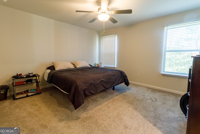 bedroom with light carpet, multiple windows, and ceiling fan