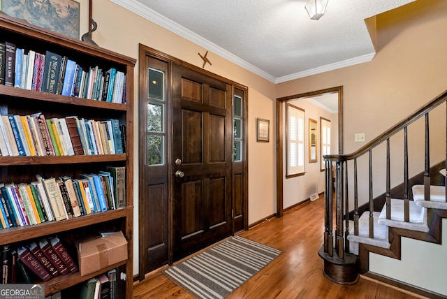 entrance foyer with crown molding, light hardwood / wood-style floors, and a textured ceiling