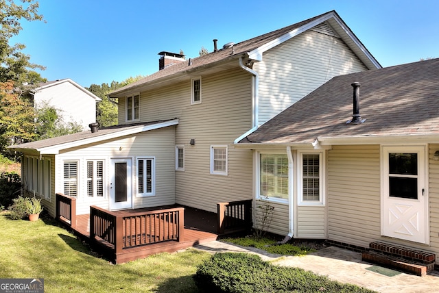 rear view of property featuring a yard and a deck