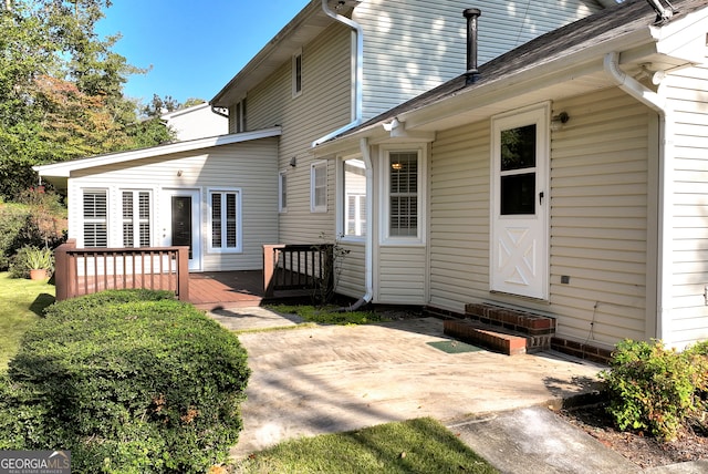 rear view of house with a wooden deck and a patio area