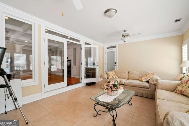 tiled living room with ceiling fan and ornamental molding