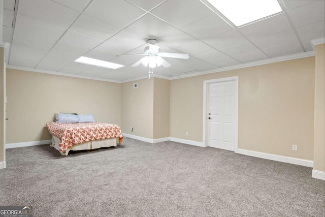 bedroom featuring a drop ceiling, carpet floors, ceiling fan, and crown molding