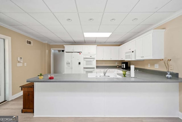 kitchen featuring white appliances, white cabinetry, crown molding, and kitchen peninsula