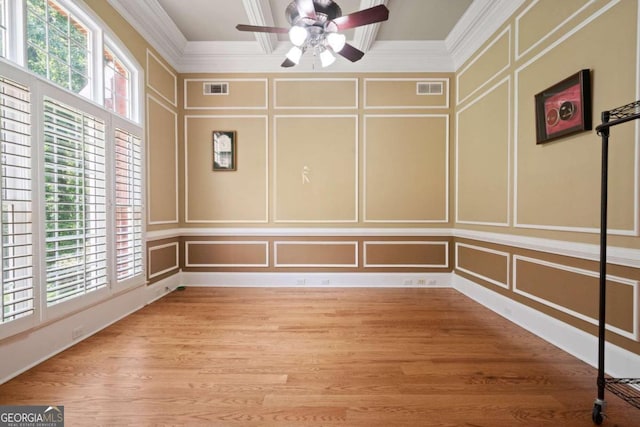 spare room with ceiling fan, ornamental molding, plenty of natural light, and light wood-type flooring