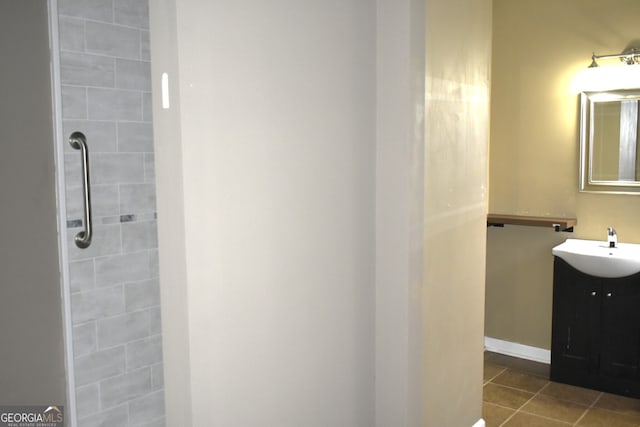 bathroom with tile patterned floors, vanity, and tiled shower