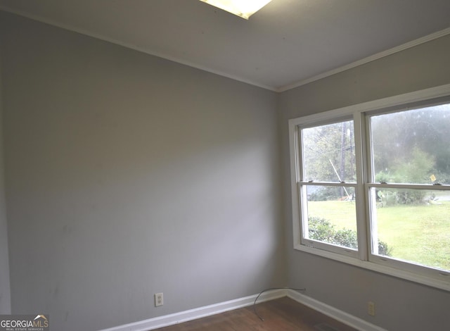 empty room with dark hardwood / wood-style flooring and crown molding