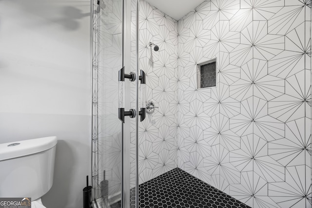 bathroom featuring a tile shower and toilet