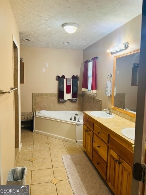 bathroom with vanity, a textured ceiling, tile patterned floors, and a tub