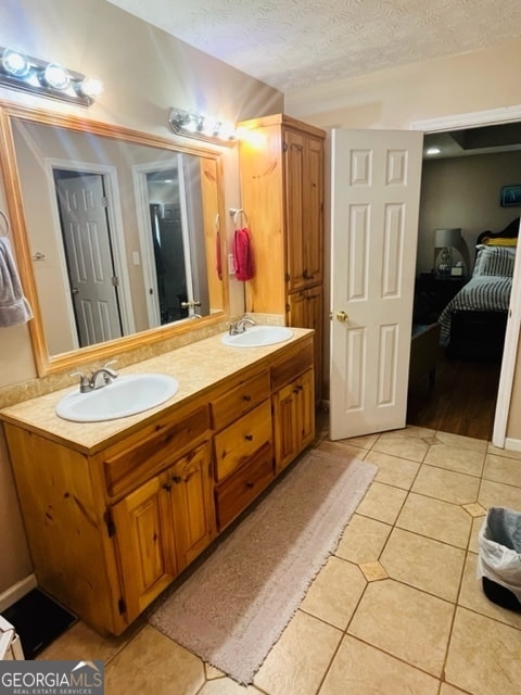 bathroom featuring tile patterned flooring, vanity, and a textured ceiling