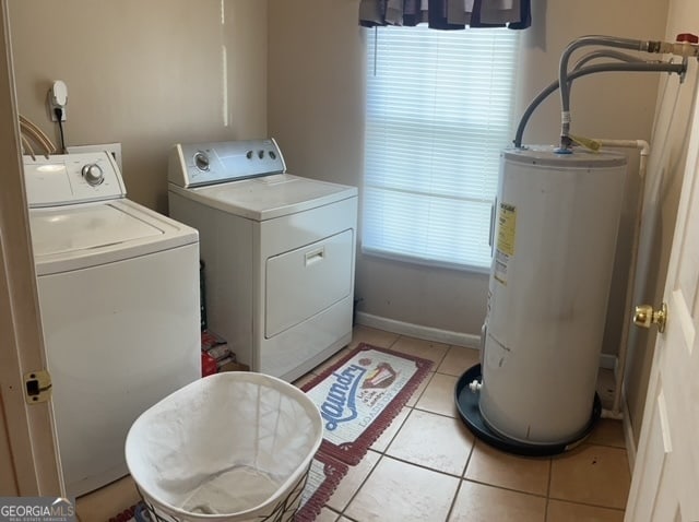 washroom featuring independent washer and dryer, light tile patterned floors, and water heater