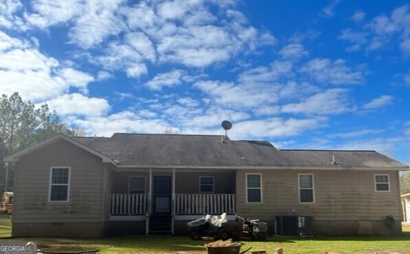 rear view of house with a lawn and cooling unit