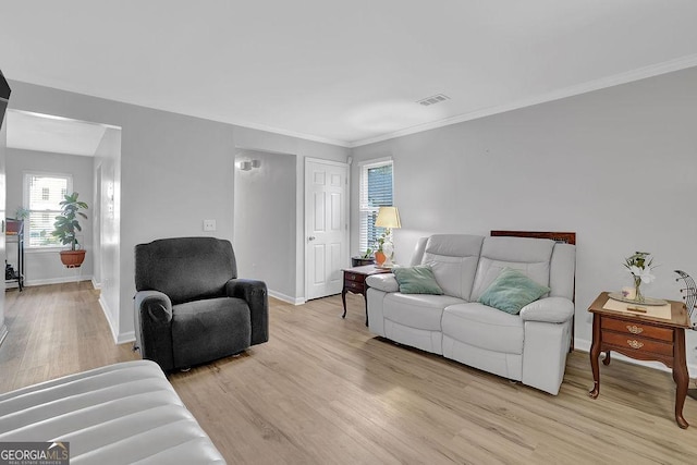 living room featuring ornamental molding and light hardwood / wood-style floors