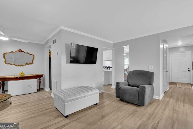 sitting room with crown molding and light wood-type flooring