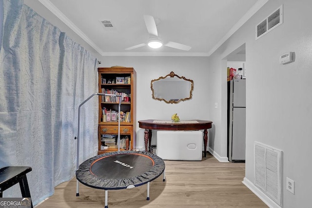 sitting room with crown molding, ceiling fan, and light wood-type flooring