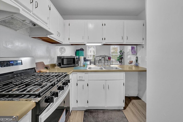 kitchen featuring white cabinetry, sink, stainless steel appliances, and light hardwood / wood-style floors