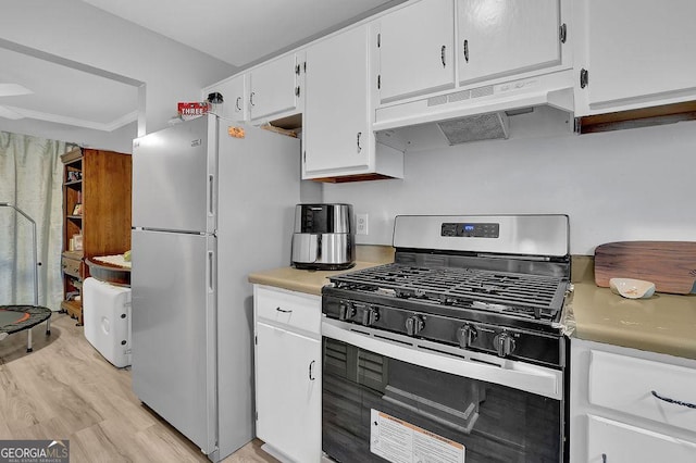 kitchen with gas range, white cabinetry, stainless steel fridge, and light wood-type flooring