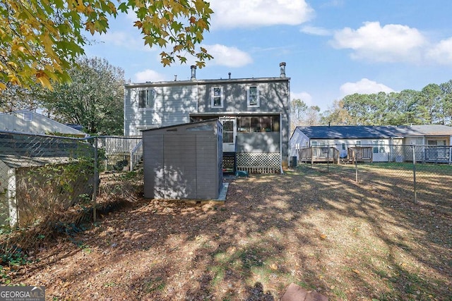 back of house with a storage unit