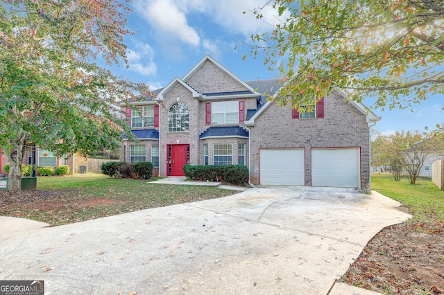 view of property with a garage and a front lawn