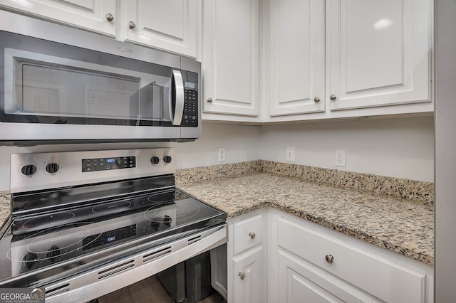 kitchen featuring white cabinets, appliances with stainless steel finishes, and light stone counters