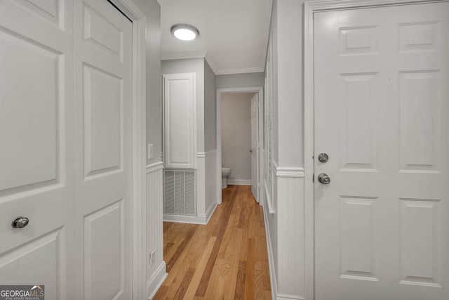 hallway featuring light hardwood / wood-style floors and ornamental molding