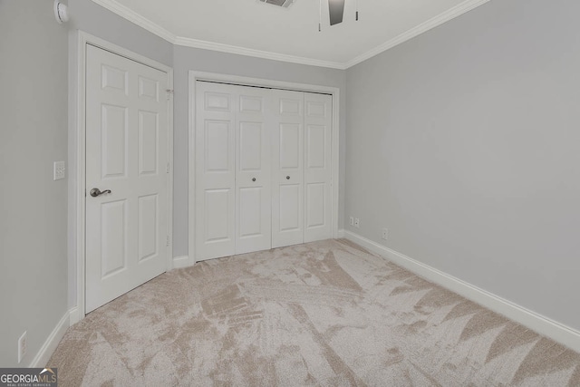 unfurnished bedroom featuring ceiling fan, light colored carpet, ornamental molding, and a closet