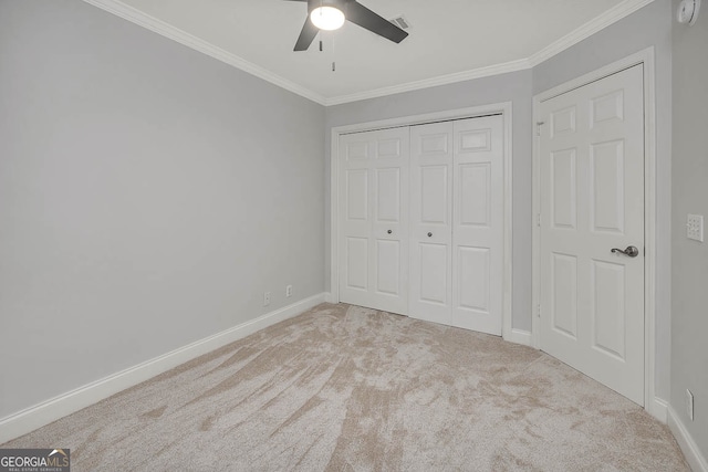 unfurnished bedroom featuring ceiling fan, ornamental molding, light carpet, and a closet