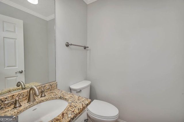 bathroom with toilet, vanity, and ornamental molding