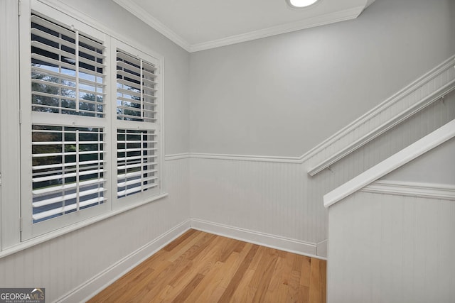 interior space with wood-type flooring and crown molding