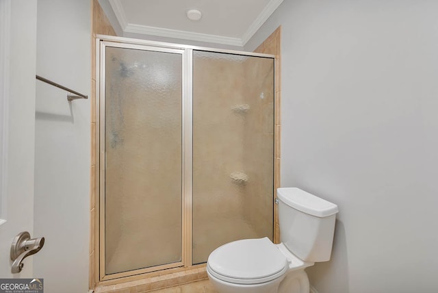 bathroom with toilet, a shower with shower door, and ornamental molding