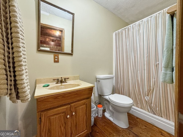 bathroom with vanity, toilet, wood-type flooring, and a textured ceiling