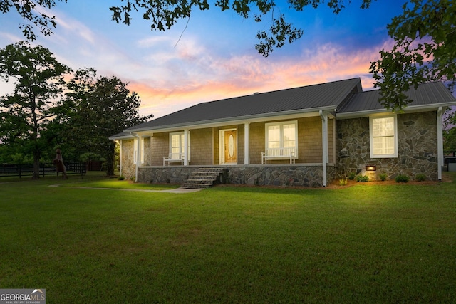 single story home with covered porch and a yard