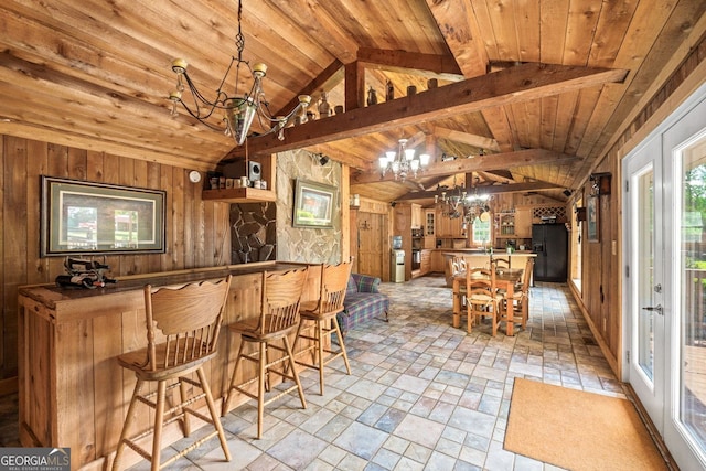 interior space with a chandelier, decorative light fixtures, and wooden walls